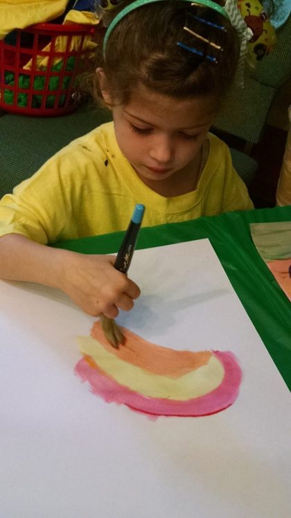 child drawing rainbow