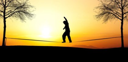 Man on tightrope at sunset